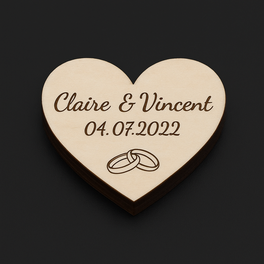 Cœur de décoration de table de mariage en bois, personnalisé avec les prénoms des mariés et la date du mariage, posé sur une table de réception élégamment dressée.